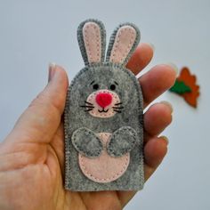 a hand holding a small felt bunny ornament