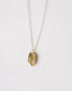 Crafted in gold vermeil and adorned with a beautiful cowrie shell charm. measures 17.75" at longest, 15.75" at shortest Tarnish Resistant Gold Beach Jewelry, Tarnish Resistant Gold Jewelry For Beach, Handmade Gold Shell Jewelry, Dainty Gold Shell Charm Necklace, Gold-plated Shell Shaped Jewelry, Dainty Gold Shell-shaped Necklace, Yellow Gold Pendant Jewelry For The Beach, Dainty Yellow Gold Necklace For Beach, Handmade Shell-shaped Yellow Gold Jewelry