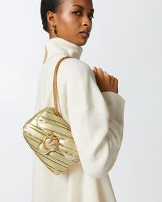 Small Baby Love Bag Puff crossbody bag in recycled-fibre leather-effect fabric with metallic golden finish and irregular pleating. This soft bag will give your elegant and special-evening outfits that sought-after finishing touch; the sliding chain strap with shoulder pad allows it to be worn either crossbody or, when doubled, on the shoulder. The bag's flap is complete with the iconic, antique gold-electroplated metal Love Birds Diamond Cut buckle, while the microsuede-lined interior features a Gold Luxe Crossbody Shoulder Bag, Gold Luxe Shoulder Bag With Dust Bag, Luxe Gold Shoulder Bag With Dust Bag, Calf Length Skirts, Soft Bag, Elegant Baby, Small Baby, Evening Outfits, Boot Pumps