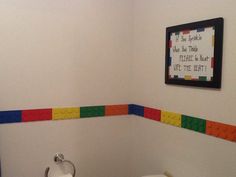 a bathroom with legos on the wall and toilet