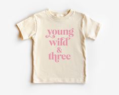 Introducing our adorable "Young, Wild, and Three" toddler tee! This fun and vibrant design is perfect for celebrating your little one's third birthday in style. Crafted with care and printed using a playful font, this tee captures the joyful spirit of your adventurous toddler. Made from soft and breathable fabric, our toddler tee ensures comfort all day long, allowing your child to freely explore their wild side. Whether they're running, jumping, or simply enjoying the party, this tee is designe Bday Party Outfit, Third Birthday Girl, Young Wild And Three, Third Birthday Shirt, Birthday Girl Outfit, Birthday Tee, Boho Retro, Third Birthday, Simple Shirts