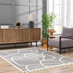 a living room with a rug, chair and sideboard