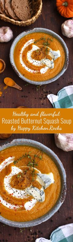 two bowls of roasted butternut squash soup on a table with bread in the background