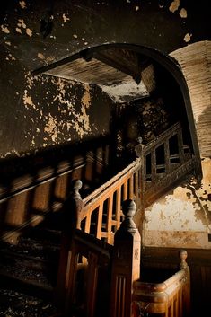 an old staircase with peeling paint on the walls and wooden railings in front of it