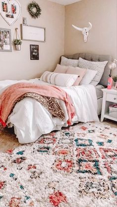 a bedroom with a bed, rugs and pictures on the wall above it is shown