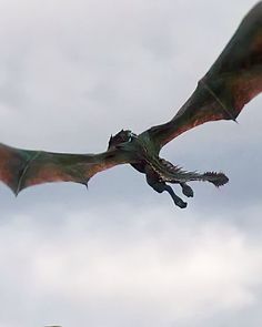 a large green dragon flying through the sky