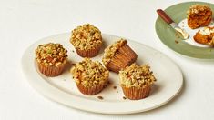 several muffins on a plate next to a bowl of yogurt