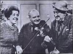 an old black and white photo of three people playing the violin while smiling at each other