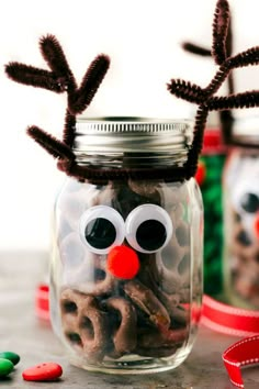 two mason jars with reindeer noses and pretzels in them, one is filled with candy