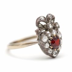 I've decided to sell some pieces from my personal collection as they aren't getting enough wear. This piece is an absolutely gorgeous Victorian bowed heart ring crafted in 14k white gold, rose cut diamonds and a 4.5mm old cut garnet. Ring face measures 15 x 10mm. Ring size 5.5. Would make a darling engagement ring.Sizing availableLayaway available Wedding Rings With Garnet And Rose Cut Diamonds, Wedding Rings With Rose Cut Diamonds And Garnet, Victorian Ruby Ring With Rose Cut Diamonds For Wedding, Heirloom Jewelry With Rose Cut Heart Diamonds, Wedding Jewelry With Rose Cut Diamonds And Garnet, Victorian Ruby Ring With Single Cut Diamonds For Wedding, Vintage Garnet Rings With Rose Cut Diamonds, Pear-shaped Ruby Ring With Rose Cut Diamonds For Wedding, Diamond Bows