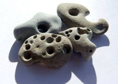 three rocks with holes in them on a white surface