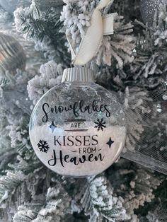 snowflakes are kisses from heaven ornament on a christmas tree in silver and white