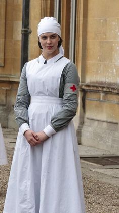 a woman in a white dress with a red cross on the chest and headband