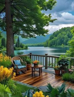 a wooden deck with chairs and flowers on it next to a lake in the woods