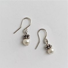 Small silver earrings with an asian silver ornament and fresh water pearls. You can buy the pair or a single earring. Everyday Hypoallergenic White Gold Pearl Earrings, Classic Silver Pearl Earrings For Everyday, Dainty Silver Pearl Earrings For Pierced Ears, Classic Sterling Silver Nickel-free Pearl Earrings, Classic Nickel-free Sterling Silver Pearl Earrings, Everyday Sterling Silver Pearl Earrings In White Gold, Everyday White Gold Sterling Silver Pearl Earrings, Silver Earrings With Pearl Charm, Dainty Pearl White Earrings