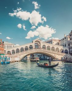 a gondola on the water in front of a bridge