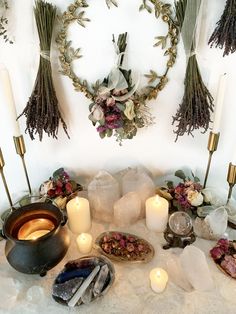 a table topped with lots of different types of candles and flowers on top of it