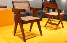 two wooden chairs sitting on top of a yellow floor