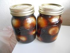 two jars filled with food sitting on top of a table