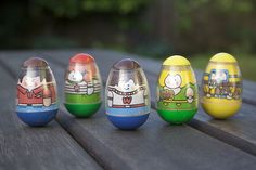 five painted eggs sitting on top of a wooden table