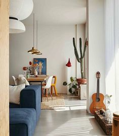 a living room filled with furniture and a guitar