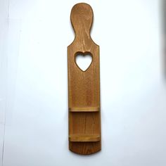 a wooden cutting board with a heart cut out of it's side on a white surface