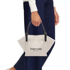 Carry your essentials in style with the Amalfi Small Canvas Tote Bag. From the Amalfi Collection by TOM FORD, this bag is made of durable canvas and features logo lettering for a chic touch. Perfect for everyday use, it's a practical and fashionable choice. Tan Coated Canvas Shoulder Bag, Designer Canvas Bag With Removable Pouch For Shopping, Tan Bucket Bag With Dust Bag For Daily Use, Tan Bags With Dust Bag For On-the-go, Designer White Canvas Bag, Designer Tan Canvas Shoulder Bag, On-the-go Tan Shoulder Bag With Dust Bag, Chic Coated Canvas Bucket Bag For Shopping, Designer Canvas Bags For On-the-go