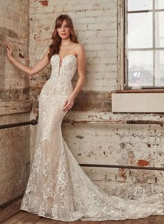 a woman in a wedding dress leaning against a brick wall