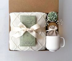 a gift box with a coffee mug, tea bag and succulents