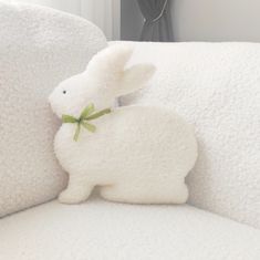 a stuffed rabbit sitting on top of a white couch