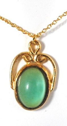 "This vintage piece is just so pretty! The green cabochon looks almost transparent against the gold tone. Hangs from a vintage 16\" chain and measures approximately 1 1/8\" in height and 3/4\" wide." Green Cabochon Oval Pendant Necklace, Oval Cabochon Brass Necklace, Vintage Yellow Gold Cabochon Necklace, Vintage Green Oval Cabochon Jewelry, Formal Green Cabochon Necklace, Green Metal Cabochon Jewelry, Green Cabochon Metal Jewelry, Vintage Green Oval Necklace, Green Cabochon Costume Jewelry