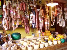 an outdoor market with meat hanging from the ceiling