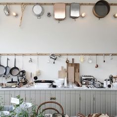 a kitchen with pots and pans hanging from the ceiling, along with other cooking utensils