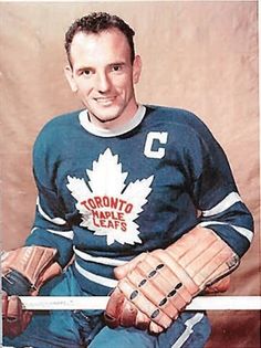 an old photo of a hockey player with his gloves on