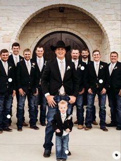 a group of young men standing next to each other in front of a stone building