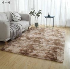 a living room with a white couch and brown rug