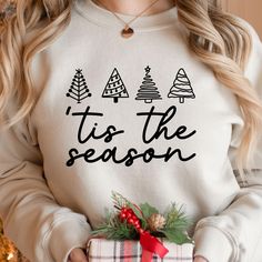 a woman wearing a sweatshirt that says tis the season