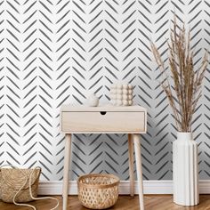 a white table sitting next to a wall with grey chevrons on it