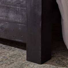 a close up of a bed with a wooden headboard and foot board on it