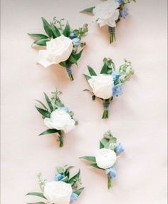 white and blue flowers are arranged on a table