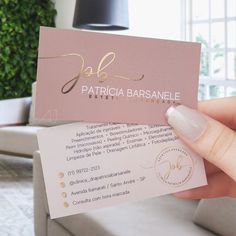 a person holding up a business card with gold foil on the front and back of it