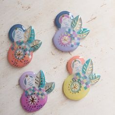 four colorful buttons with designs on them sitting next to each other in the shape of an owl