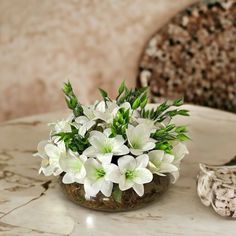 a vase with white flowers on a marble table