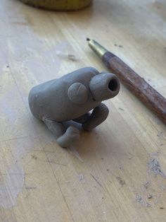 an elephant figurine sitting on top of a wooden table next to a hammer