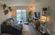 a living room filled with furniture and lots of plants