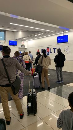 people waiting in line at an airport for their luggage to be picked up or taken off