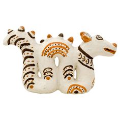 two white and brown ceramic zebras sitting next to each other on a white background