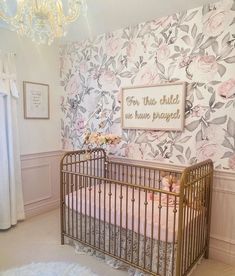 a baby's room with floral wallpaper and gold crib