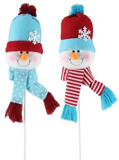 two snowman lollipops with hats and scarves on them