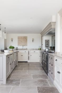 a large kitchen with white cabinets and gray flooring